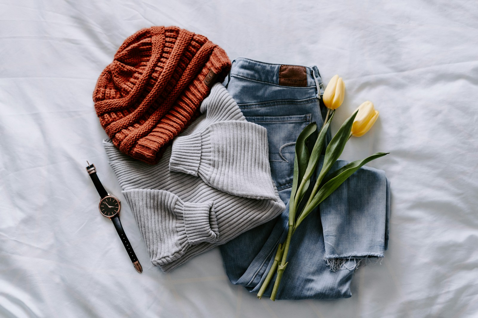 Curated knitwear and denim garments arranged for product development